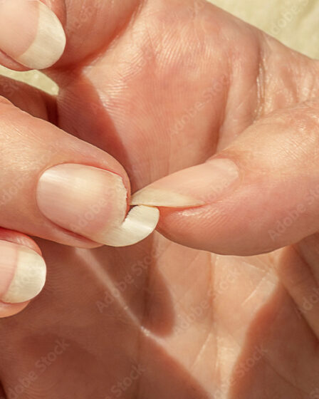 Broken nail. Natural long nails without polish. Cracked, chipped nail. Female fingernails polish-free.